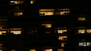 Ventanas iluminadas de un edificio de noche, el papel de los testigos